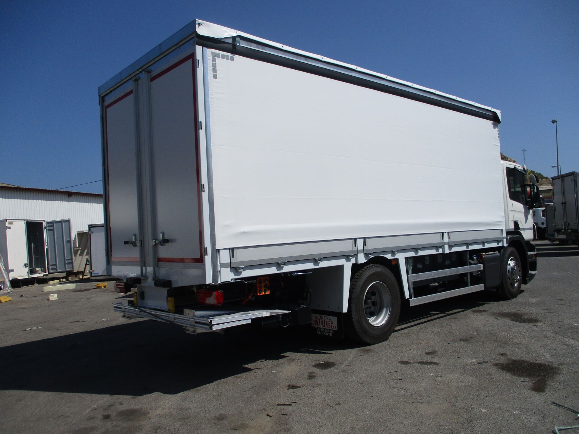 Un camión blanco grande está estacionado en un estacionamiento.