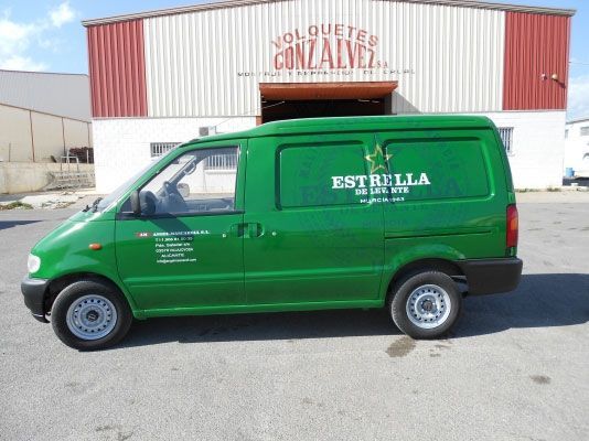 Una camioneta verde con la palabra estrella escrita en el costado está estacionada frente a un edificio.