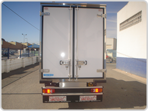Un camión blanco está estacionado frente a un edificio.