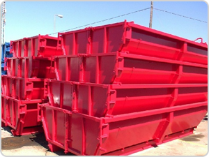 Un montón de contenedores de basura rojos están apilados uno encima del otro.