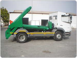 Un camión volquete verde está estacionado en un estacionamiento