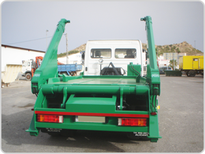 Un camión volquete verde está estacionado en un estacionamiento