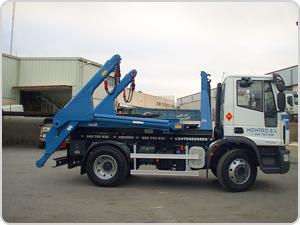 Un camión volquete está estacionado frente a un edificio