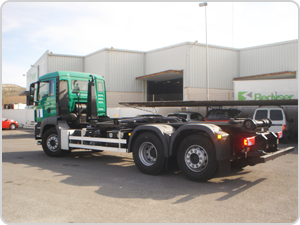 Un camión verde está estacionado frente a un edificio que dice pedigrí.