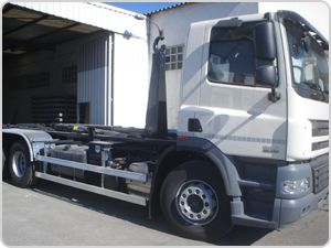 Un camión blanco está estacionado frente a un edificio.