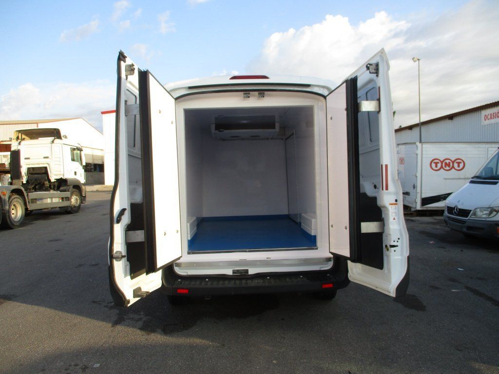 Una camioneta blanca está estacionada en un estacionamiento con las puertas abiertas