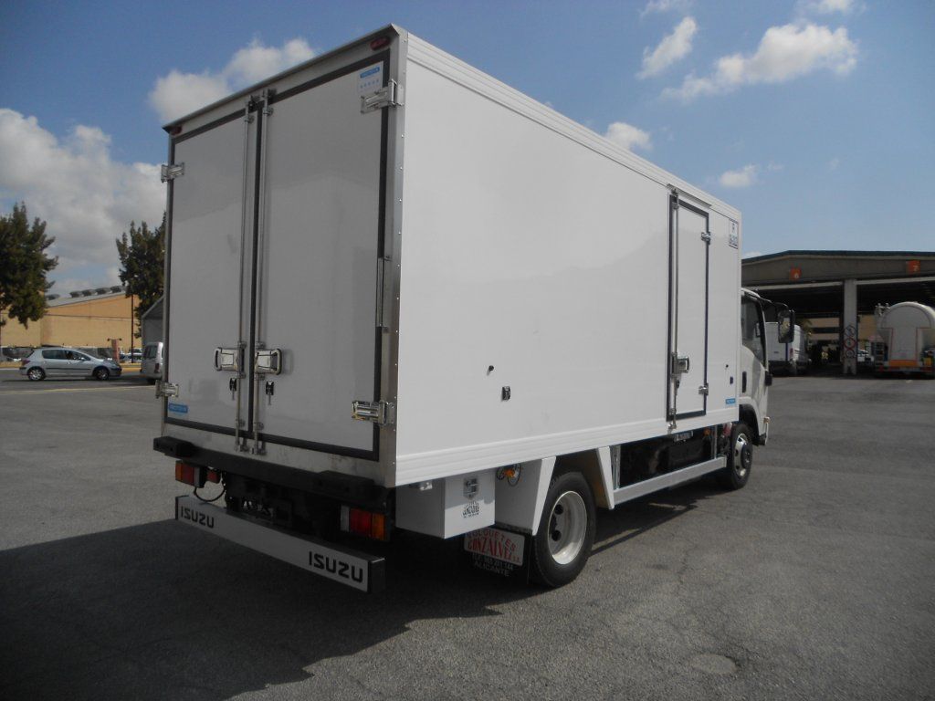 Un camión Isuzu blanco está estacionado en un estacionamiento.