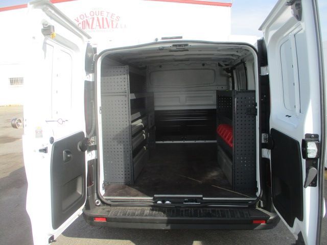 La parte trasera de una furgoneta blanca con la puerta abierta.