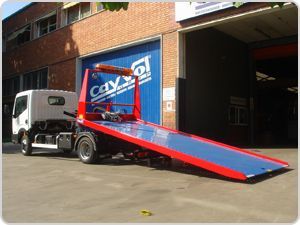 Una grúa con plataforma está estacionada frente a un edificio.