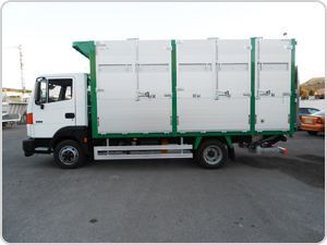 Un camión blanco y verde está estacionado en un estacionamiento.
