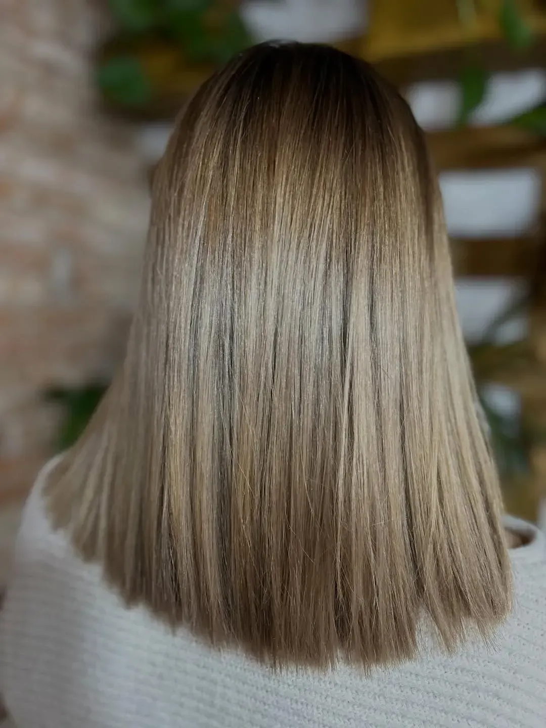 Corte bob liso castaño visto desde atrás, con reflejos sutiles y un corte recto y uniforme.