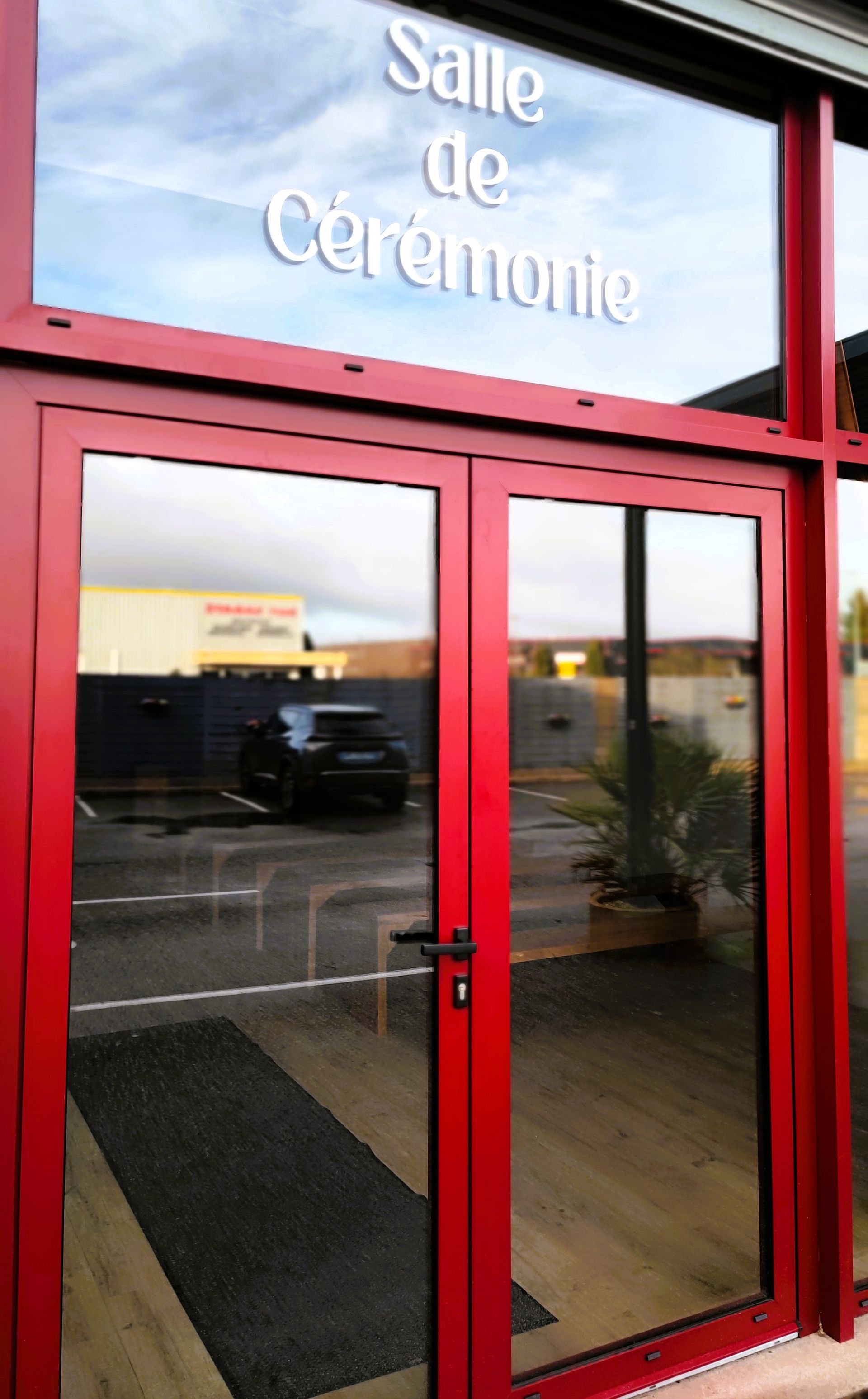Porte rouge ouvrant vers la salle de cérémonie des pompes funèbres Leydet