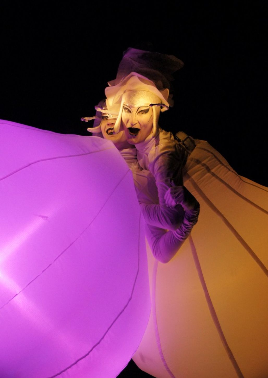 Una mujer disfrazada sostiene un globo morado.