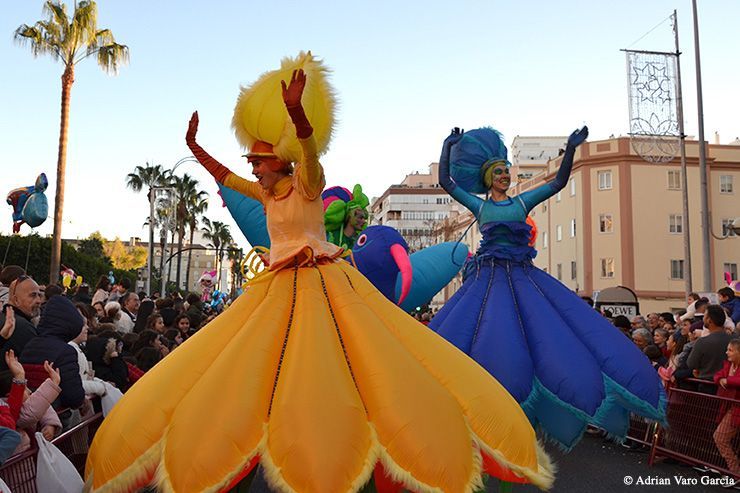 Un grupo de personas con disfraces coloridos bailan frente a una multitud.