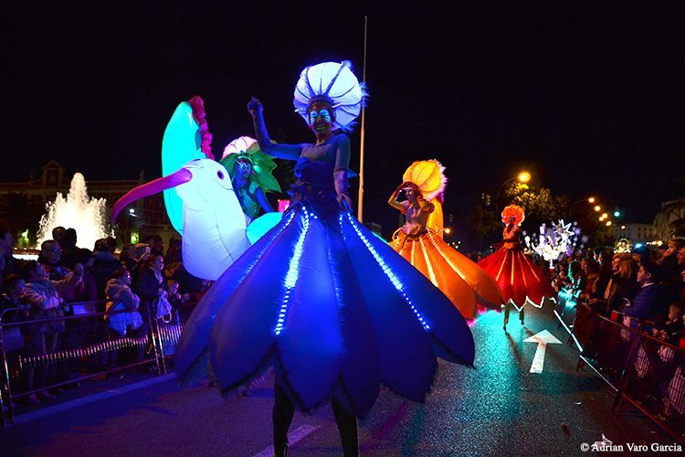 Un grupo de personas están de pie sobre zancos en un desfile.