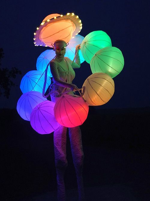 Una mujer sostiene un montón de linternas de colores.