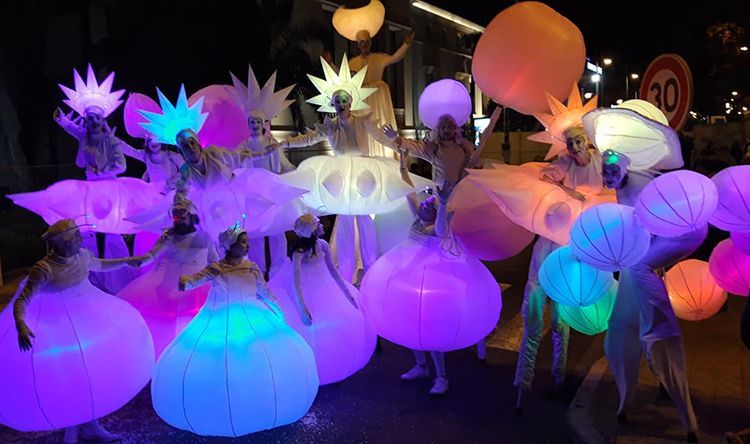 Un grupo de personas están paradas una al lado de la otra con disfraces que brillan en la oscuridad.