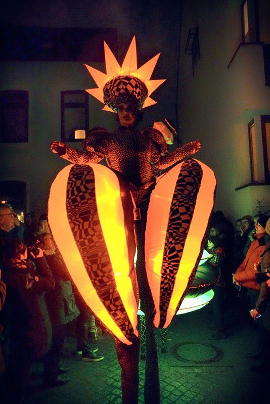 Una persona en zancos con una estrella en la cabeza
