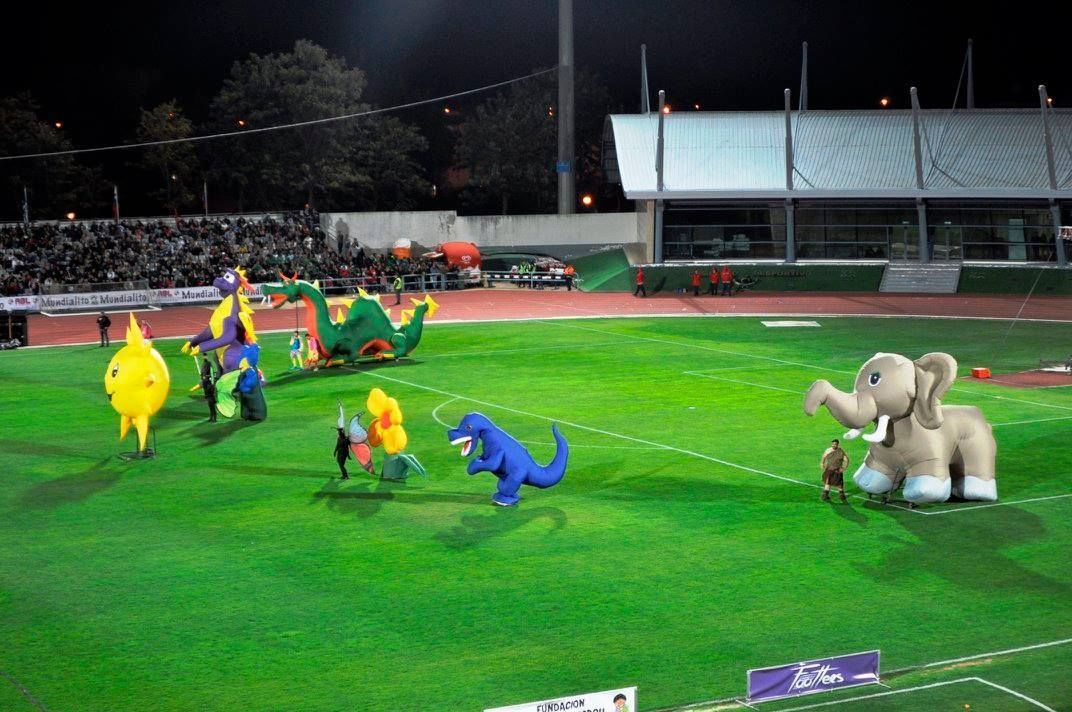 Un grupo de animales inflables están jugando en un campo de fútbol.