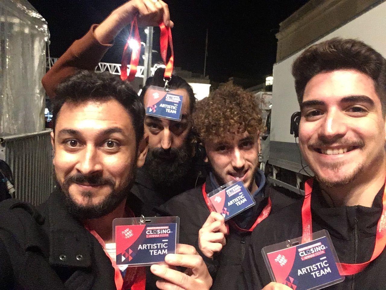 Un grupo de hombres posa para una fotografía y uno de ellos lleva una etiqueta con el nombre que dice