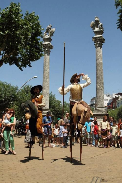 Un hombre montado a caballo sobre zancos frente a una multitud.