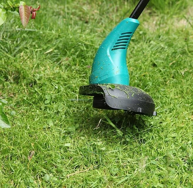 Gros plan sur la tête d'une débroussailleuse verte