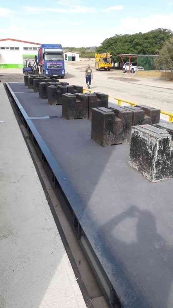 Un camión está estacionado en una báscula con mucho peso sobre él.