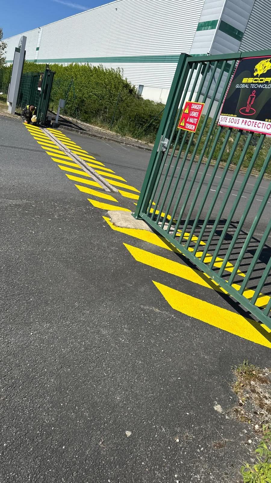 Marquage jaune au sol au niveau d'un portail