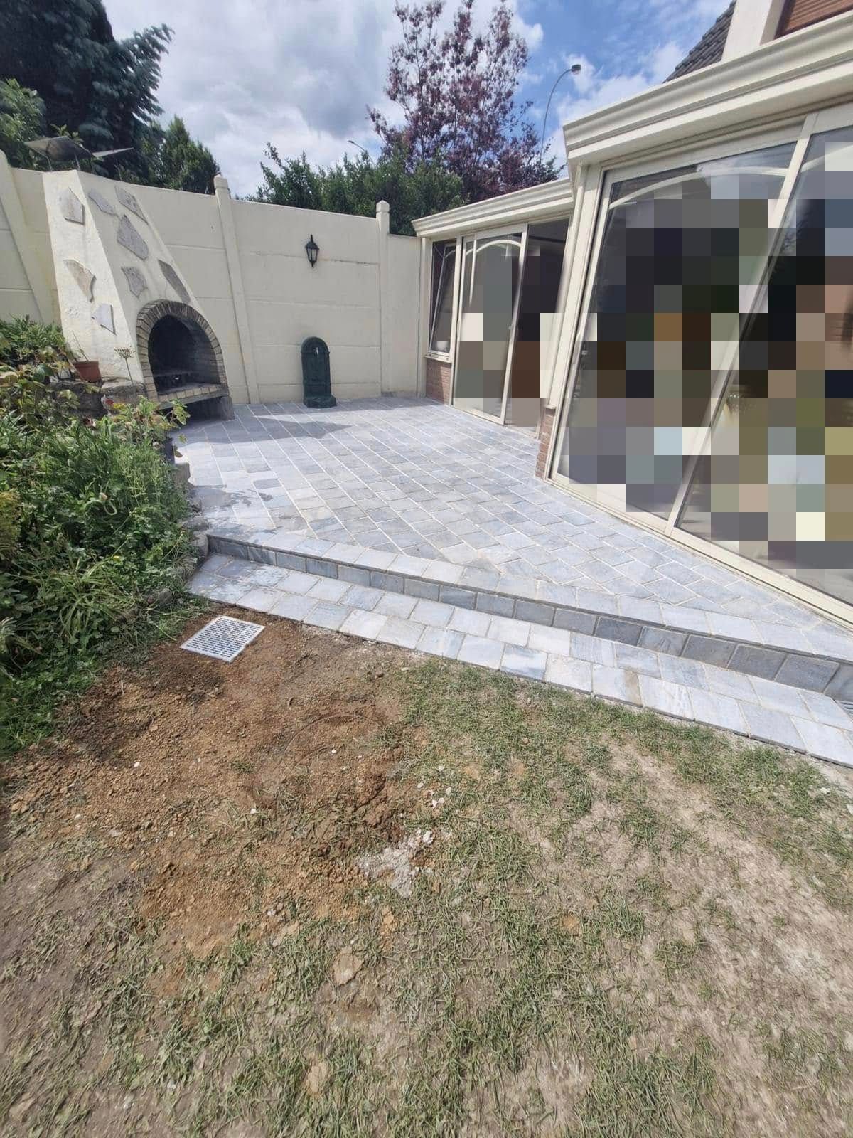 Maison avec une terrasse en pavé gris