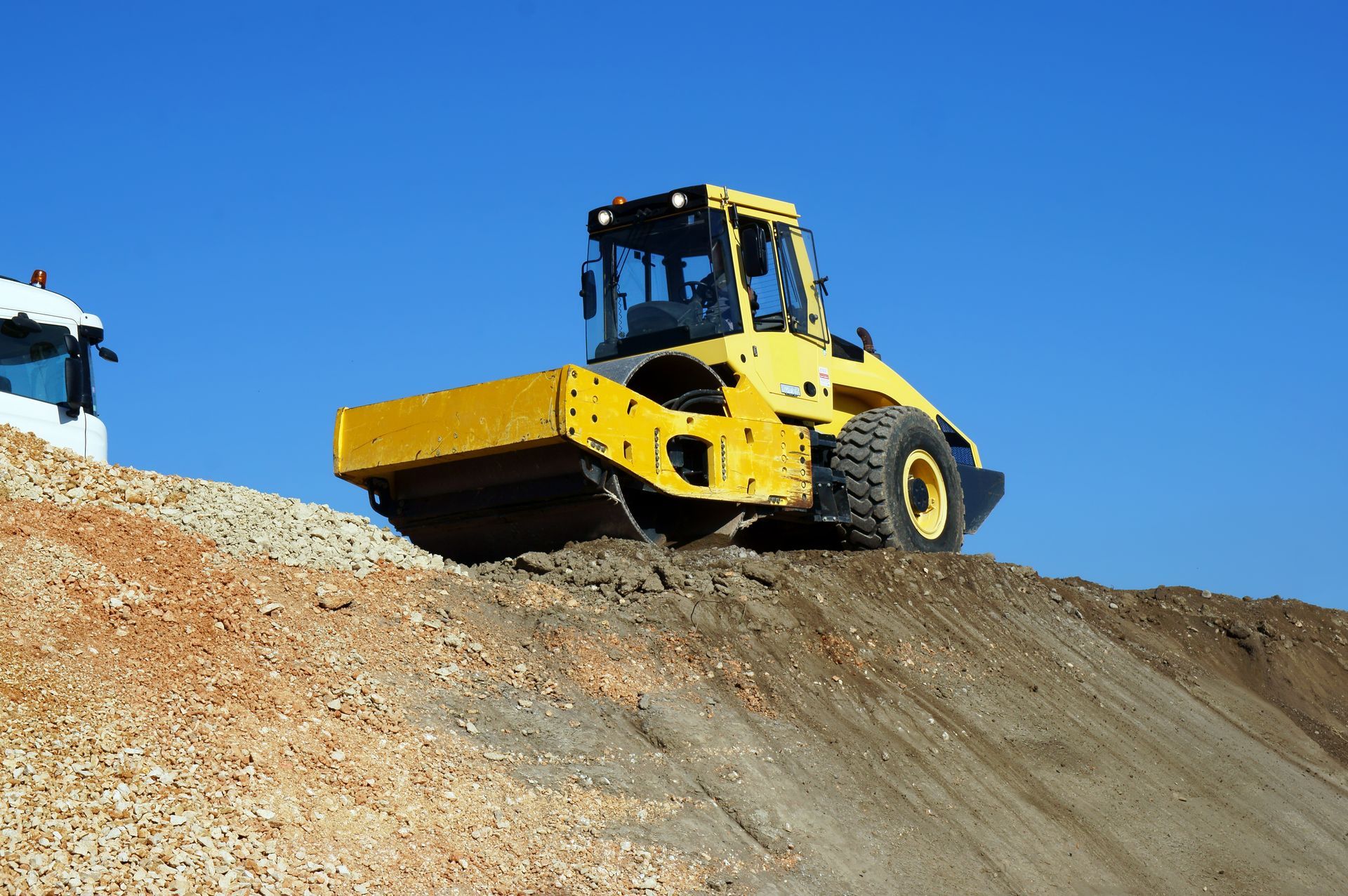 Engin de chantier en hauteur sur un tas de terre sur un chantier