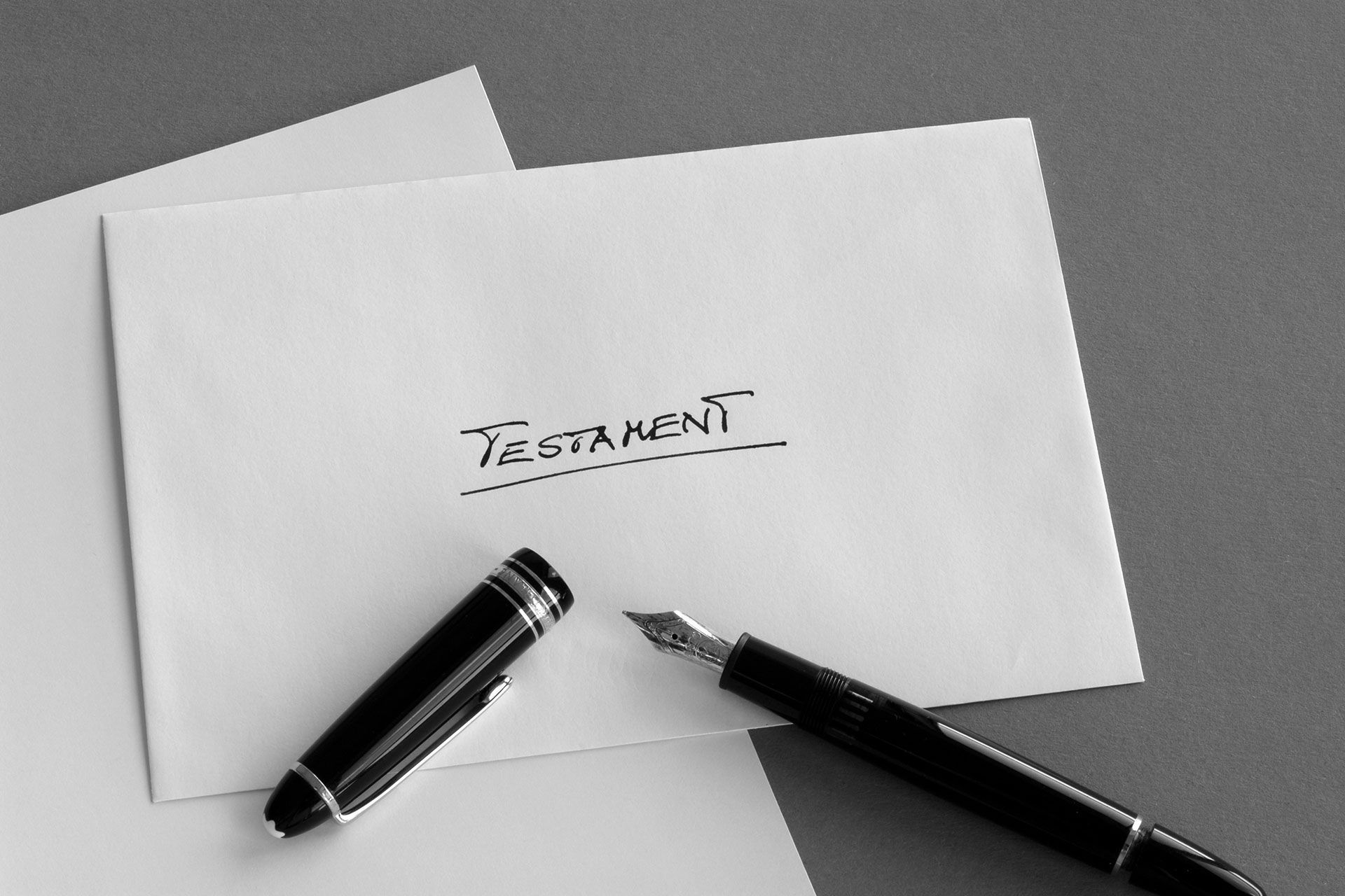 Ein Füllfederhalter liegt auf einem Stück Papier mit der Aufschrift „Testament“