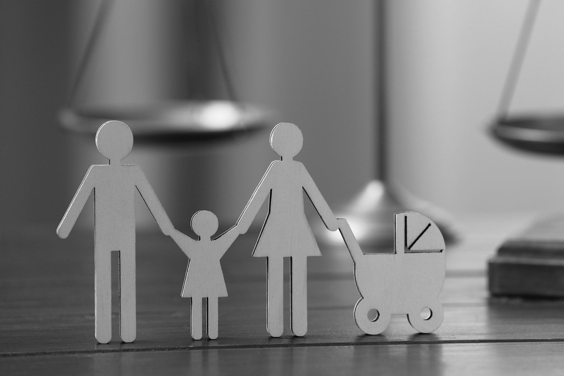 Ein Schwarzweißfoto eines Papierausschnitts einer sich an den Händen haltenden Familie.