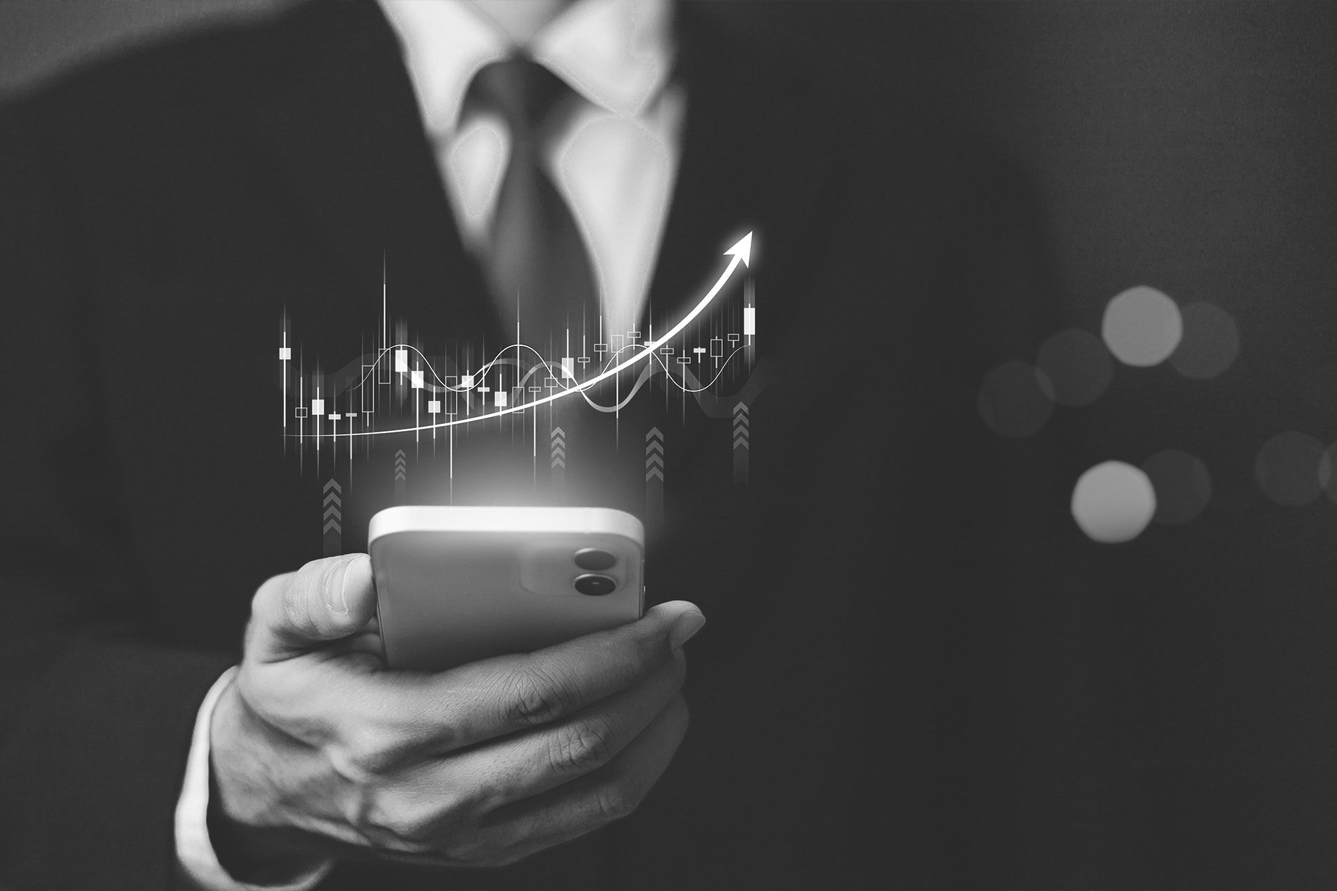 Ein Mann in Anzug und Krawatte hält ein Mobiltelefon , aus dem eine Grafik erscheint.