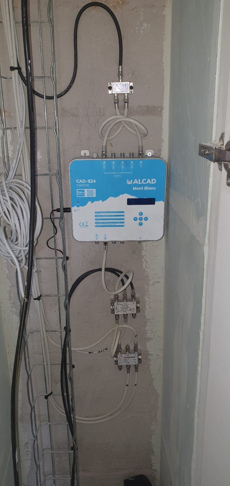Dispositif médical mural avec étiquette bleue et câbles connectés dans une buanderie