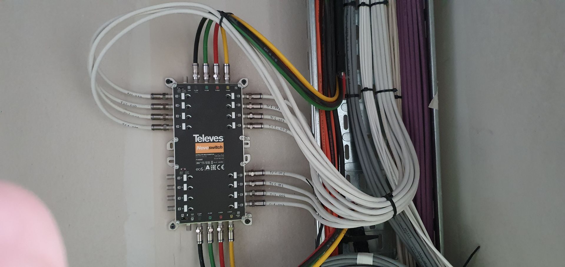 Carte de circuit imprimé câblée, fixée au mur, avec câbles et connecteurs regroupés.