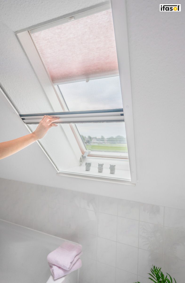 Eine Person öffnet ein Dachfenster in einem Badezimmer - Insektenschutz von Gardinen Breuß aus Elmshorn