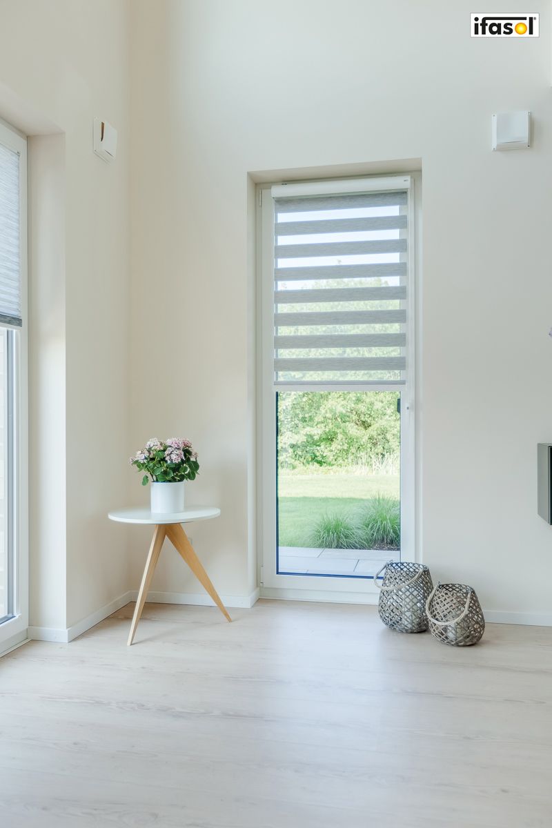 ein Wohnzimmer mit einem Tisch und einer Blume auf einem Tisch - Sonnenschutz von Gardinen Breuß aus Elmshorn