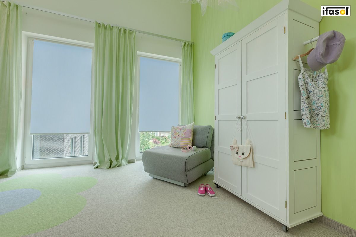 ein Schlafzimmer mit grünen Wänden , einem weißen Schrank und einem Bett - Sonnenschutz von Gardinen Breuß aus Elmshorn