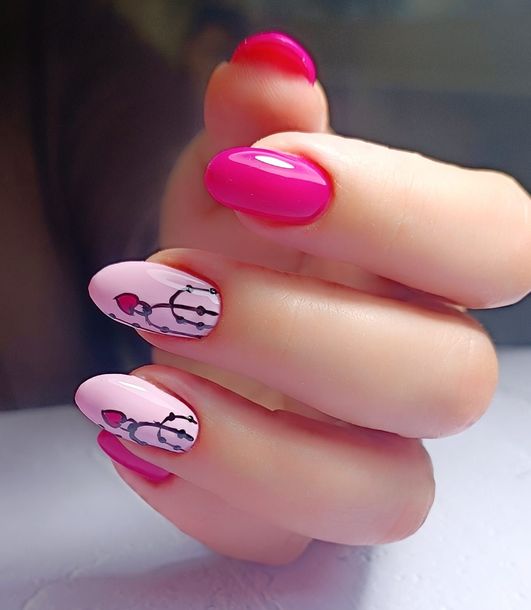 Un primer plano de la mano de una mujer con uñas rosas.