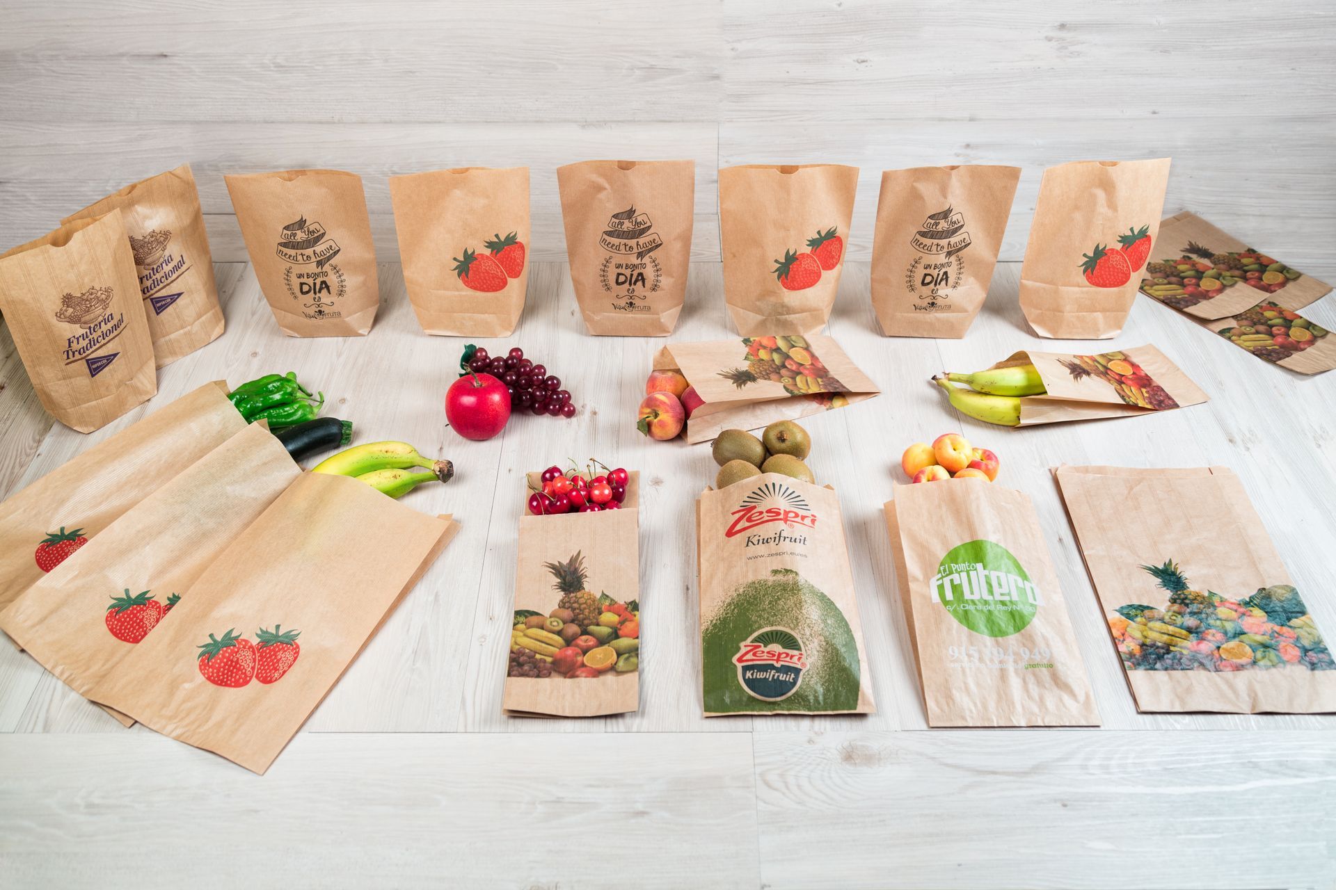 Una mesa cubierta con una variedad de bolsas de papel llenas de frutas y verduras.