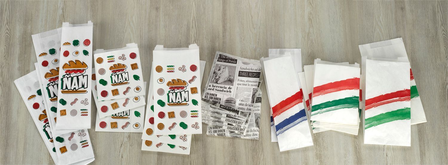 Un montón de bolsas de papel encima de una mesa de madera.