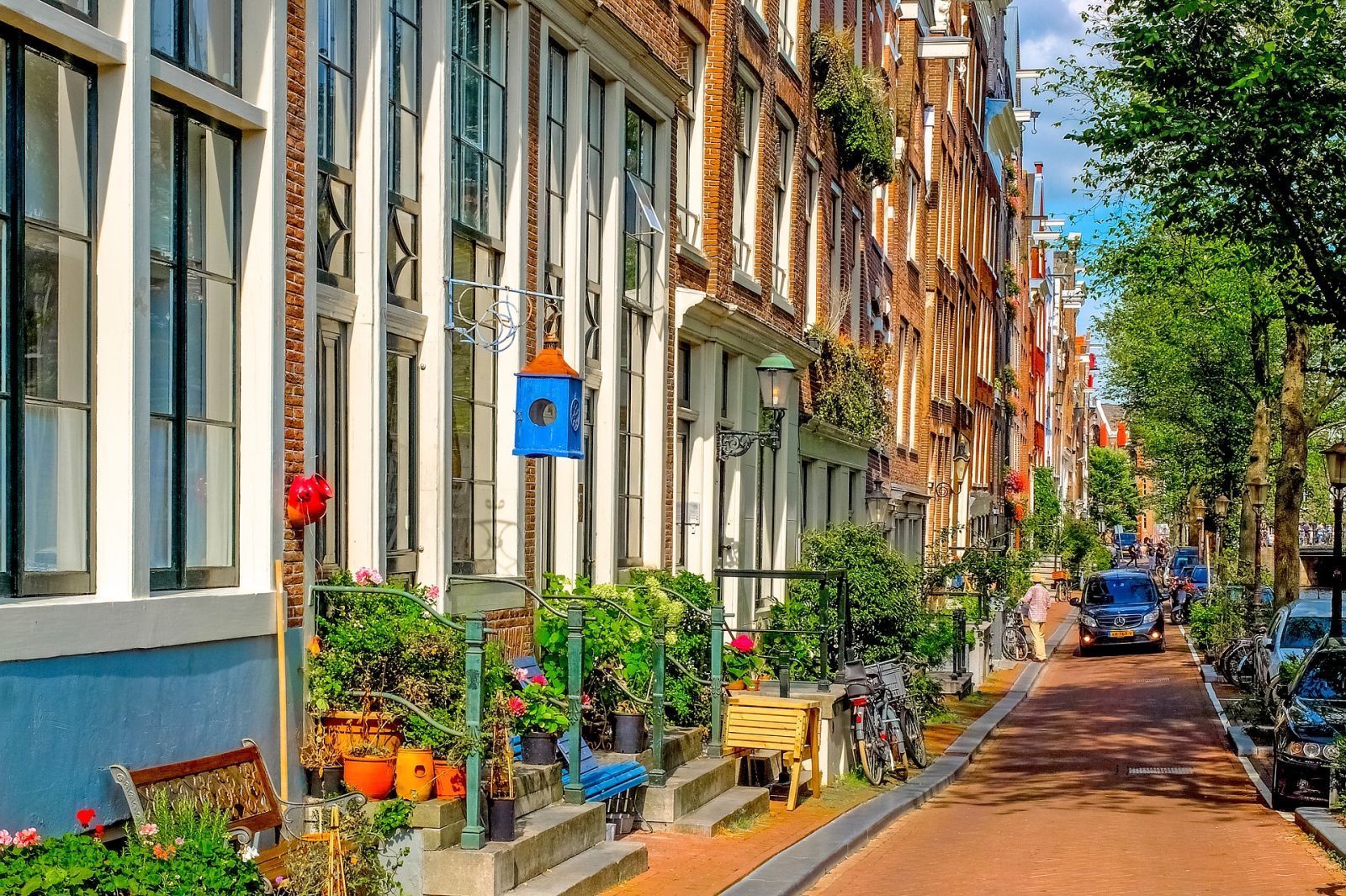 A row of buildings lined up on a narrow street in amsterdam.