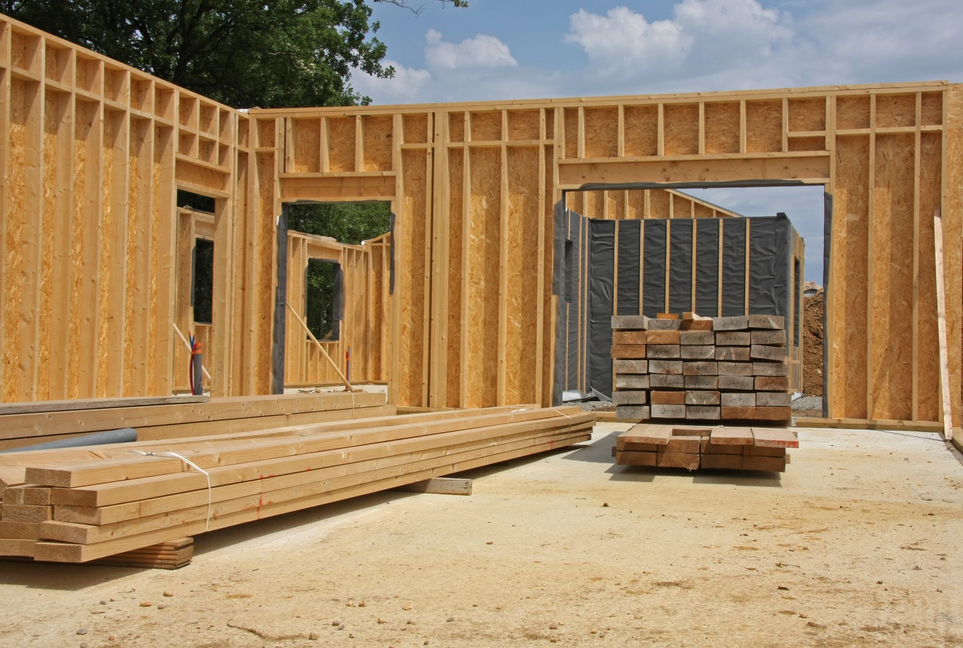 Charpente d'une maison en bois en construction, avec des lattes de bois au premier plan.