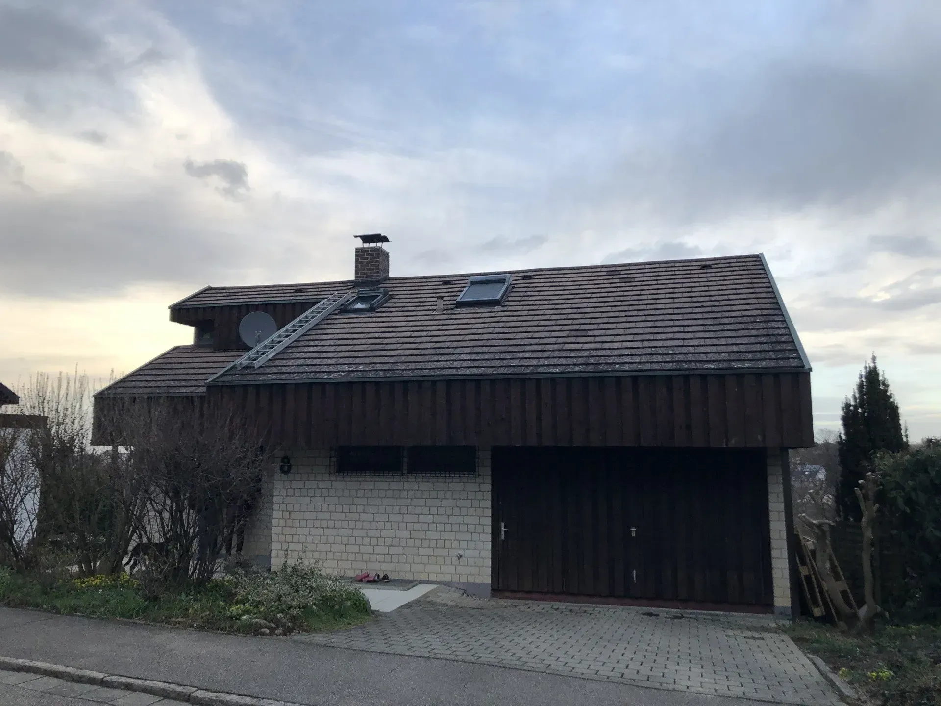 Ein Haus mit einer Garage und einem Oberlicht auf dem Dach.