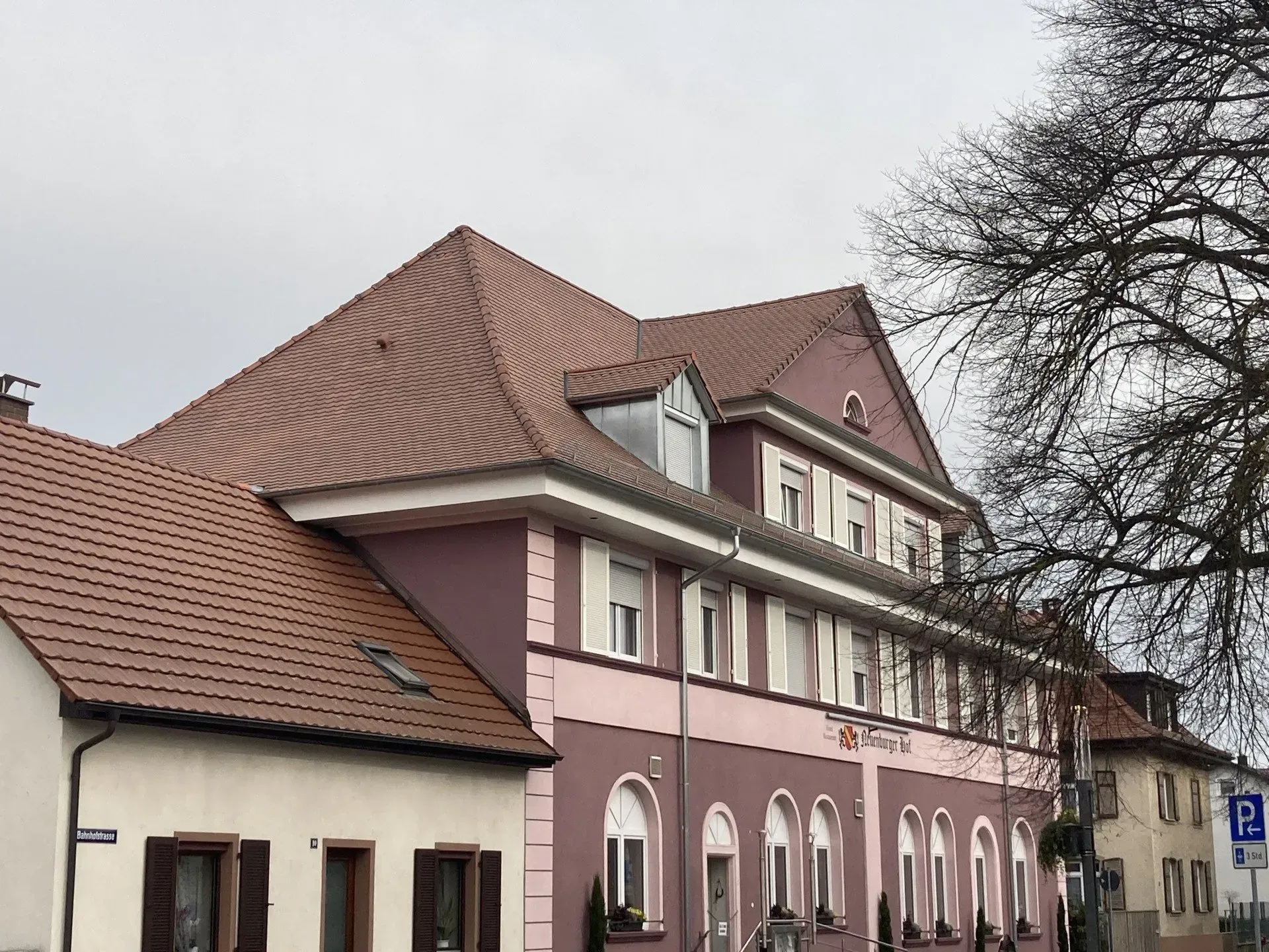 Ein großes rosa-weißes Gebäude mit einem Ziegeldach