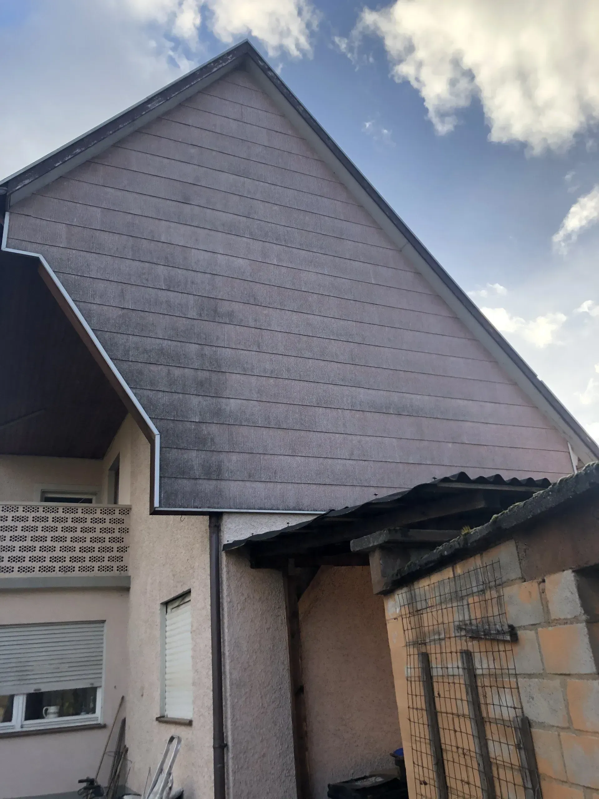 Ein Haus mit Schieferdach und Balkon