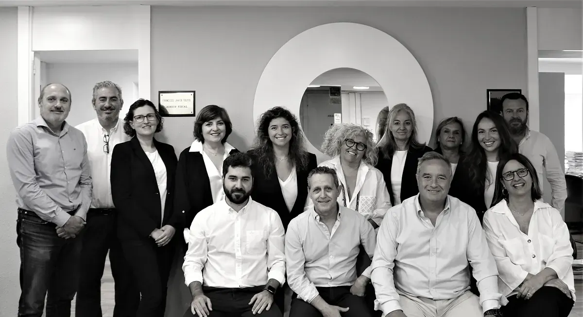 Una fotografía en blanco y negro de un grupo de personas posando para una fotografía.