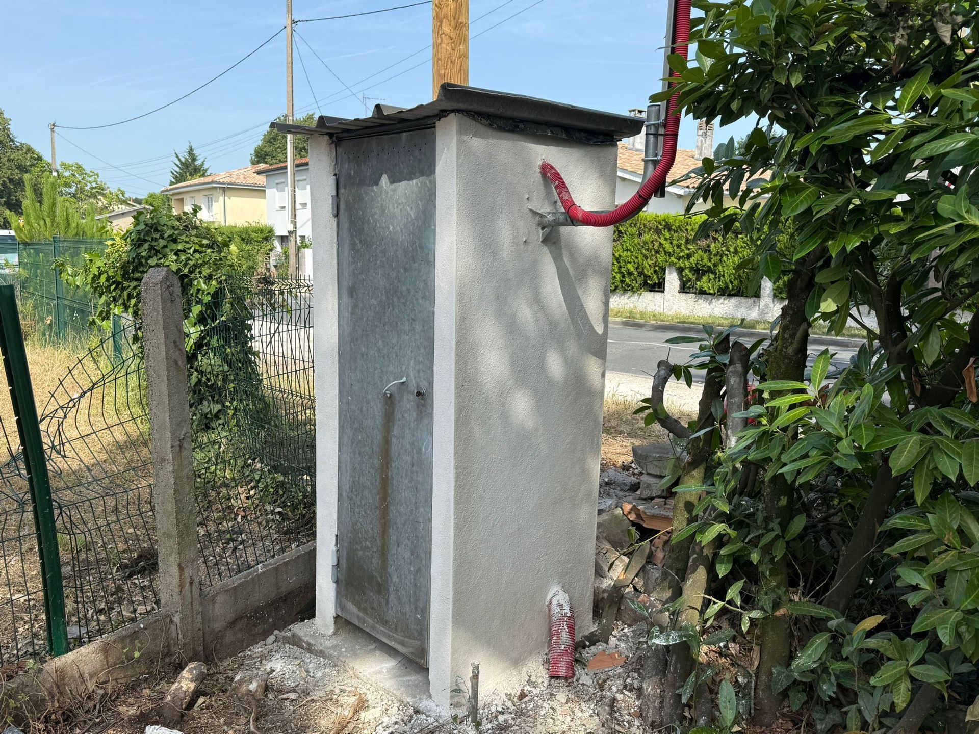 Maçonnerie d'un mur en parpaing béton terminé pour protéger une arrivée d'eau.