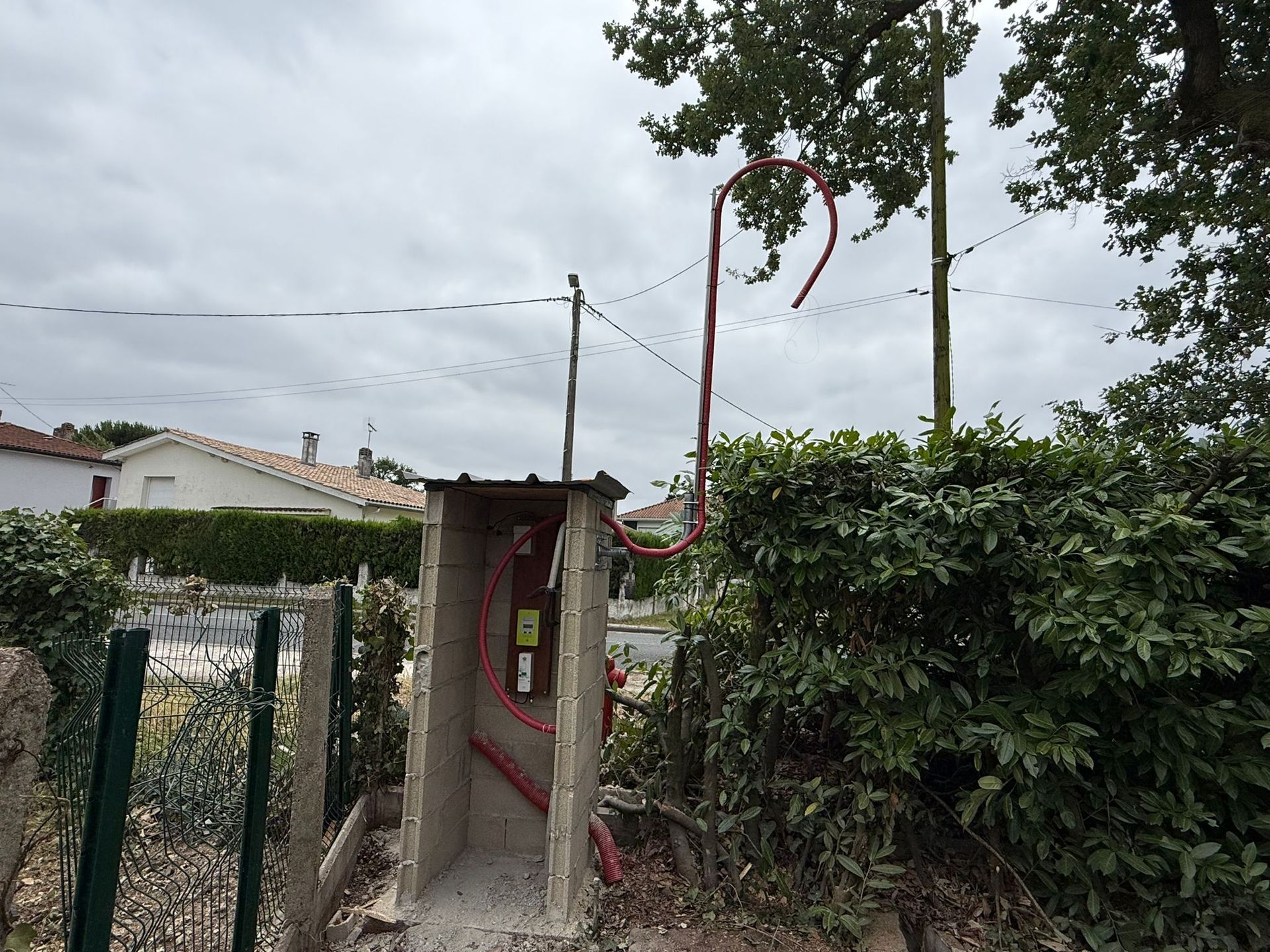 Maçonnerie d'un mur en parpaing béton en cours (phase 2) de construction pour protéger une arrivée d'eau.