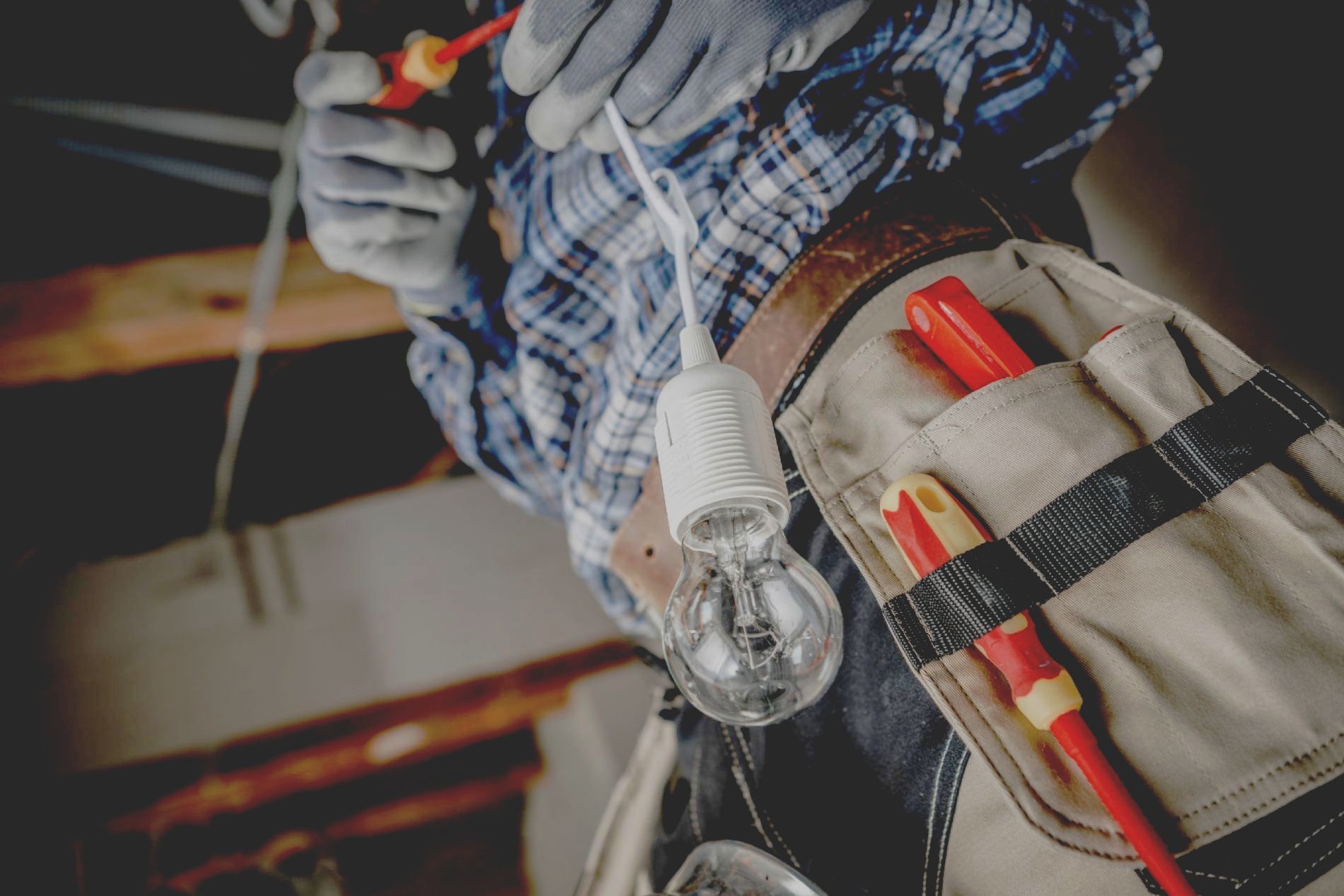 Un hombre está arreglando una bombilla con un destornillador.